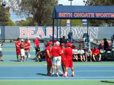 Tennis players in red in a huddle