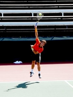 Male tennis player playing a forehand smash