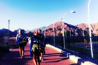 Tennis players walking away with hills in the background