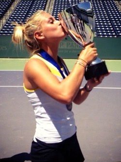 Female tennis player kissing a trophy